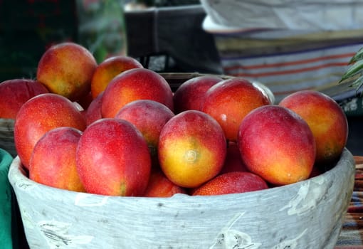 Fresh red Irwin mangoes for sale at an outdoor market