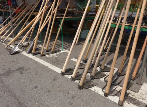 A street vendor sells handcrafted agricultural and gardening tools
