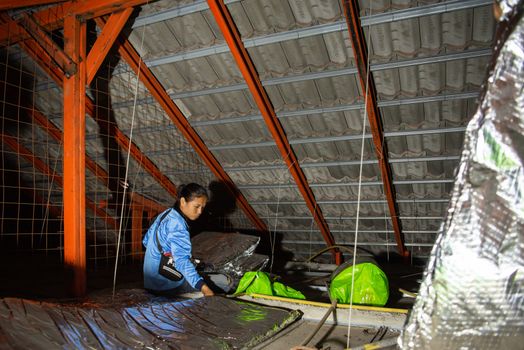 Bangkok, Thailand - January 19, 2020 : Unidentified worker to installing thermal insulation or heat insulation on home roof for heat and warm protection hot air into the home in customer home