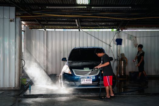 Bangkok, Thailand - February 16, 2020 : Unidentified car care staff cleaning (clean, wash, polish, wax and glass coating) the car (Car detailing) at car care shop in Bangkok Thailand