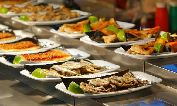 Ready to eat grilled fish dishes for sale at a market
