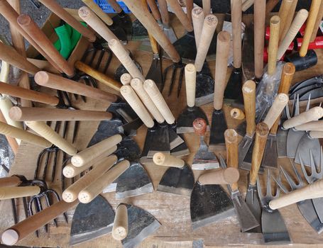 A street vendor sells handcrafted agricultural and gardening tools