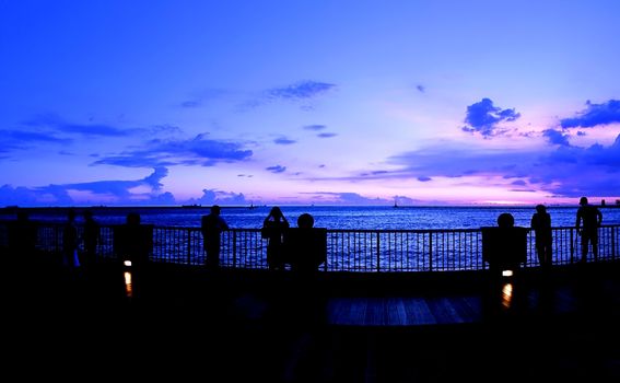 People enjoy the beautiful purple sky just after sunset
