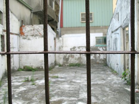 Old rusty iron bars that are part of a deserted, broken house
