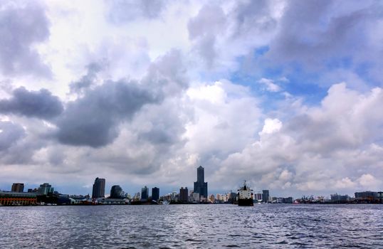 The skyline of Kaohsiung city and port under a dramatic sky
