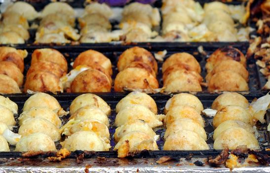 A street vendor cooks Japanese Takoyaki, or squid balls