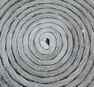 An old rope is stored in a coil shape