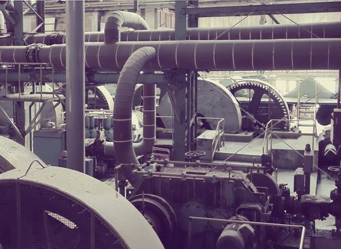 Rusting machinery and equipment in an abandoned old factory. Vintage color processing
