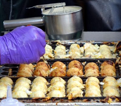 A street vendor cooks Japanese Takoyaki, or squid balls
