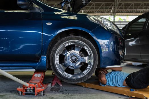 Bangkok, Thailand - August 31, 2017 : Unidentified car mechanic or serviceman checking a car engine for fix and repair problem at car garage or repair shop