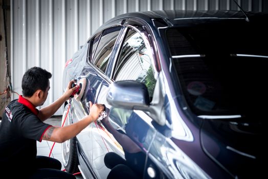 Bangkok, Thailand - November 9, 2019 : Unidentified car care staff cleaning (clean, wash, polish and wax) the car (Car detailing) at car care shop in Bangkok Thailand