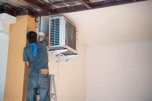 Bangkok, Thailand - January 12, 2020 : Unidentified worker to cleaning coil cooler of air conditioner by water for clean a dust on the wall in customer home when maintenance service