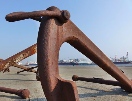 Large rusty buoy anchor encrusted with barnacles
