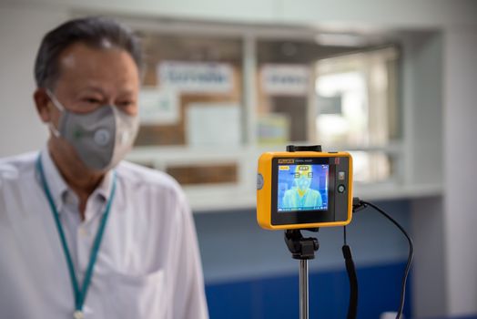 Bangkok, Thailand - March 18, 2020 : Unidentified people waiting body temperature check to access building for against epidemic flu covid19 or corona virus by thermoscan or infrared thermal camera