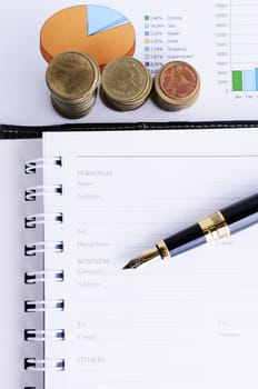 Business Fountain pen and Coins on document report