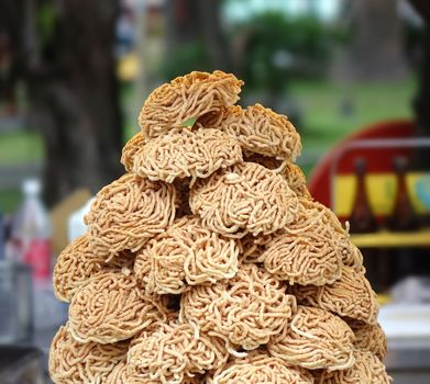 A street vendor shows a pile of ready to cook noodles
