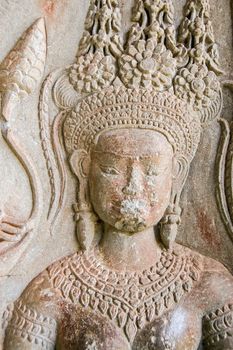 Close up of a carved stone Apsara goddess. One of the many carvings of sacred dancers at the ancient Khmer temple of Angkor Wat, Siem Reap, Cambodia.