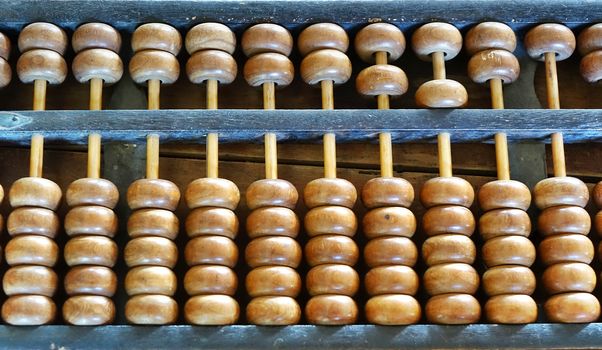 A vintage Chinese abacus or counting frame with two beads in the upper and five in the lower deck.