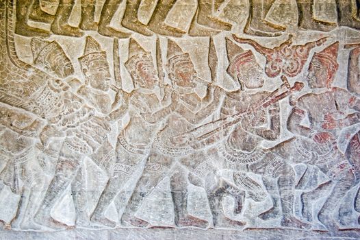 Khmer bas relief carving of an army band marching into battle. Frieze on Northern gallery, Angkor Wat Temple, Siem Reap, Cambodia.