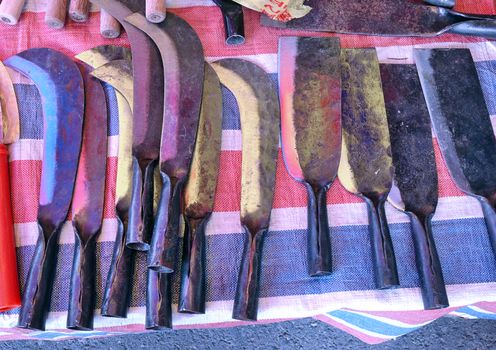 A street vendor sells handcrafted agricultural and gardening tools