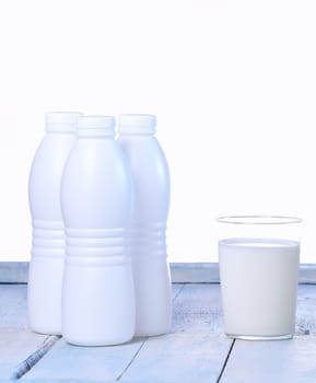 Glass of fresh milk on wooden table in the kitchen.