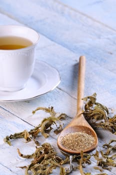 Cup of tea with herbal tea on wooden table.