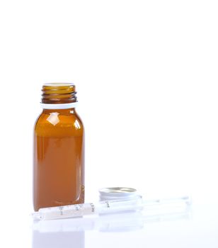 Syrup bottle with syringe on white background.