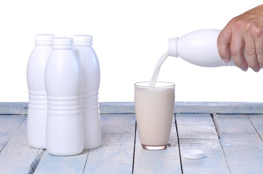 Glass of fresh milk on wooden table in the kitchen.
