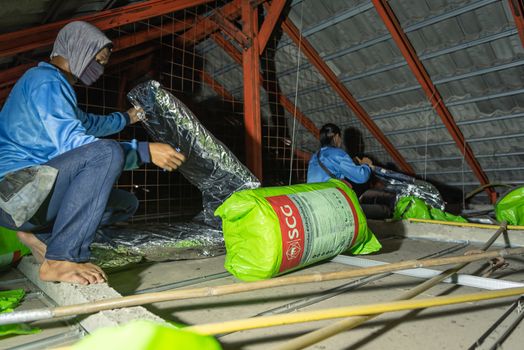 Bangkok, Thailand - January 19, 2020 : Unidentified worker to installing thermal insulation or heat insulation on home roof for heat and warm protection hot air into the home in customer home