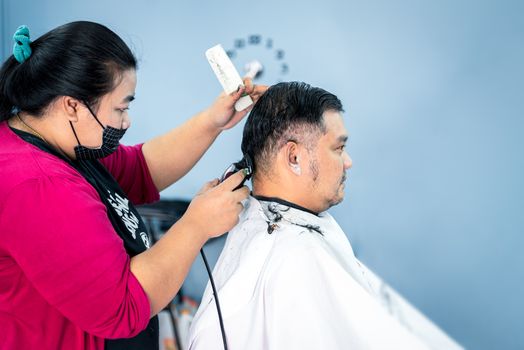 Bangkok, Thailand - February 2, 2020 : Unidentified asian man hairdresser or hairstyle haircut a man plump body customer in fashion hairstyle at barbershop