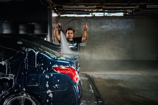 Bangkok, Thailand - September 2, 2017 : Unidentified car care staff cleaning (clean, wash, polish, wax and glass coating) the car (Car detailing) at car care shop in Bangkok Thailand