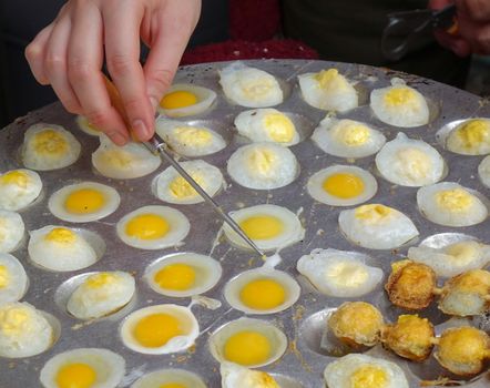A street vendor cooks poached quail eggs, a popular snack in Taiwan