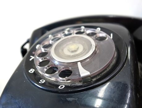 A black vintage rotary dial phone with a circular dialing wheel
