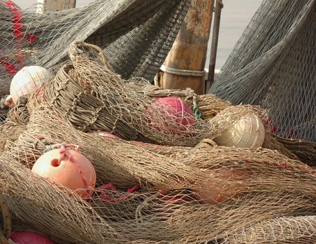 A pile of old fishing nets with hollow round plastic floats
