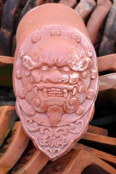 Kiln fired Chinese eave tile end with image of a house god
