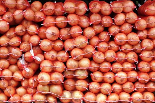 Large sacks of onions are sold at an outdoor market