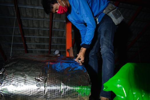 Bangkok, Thailand - January 19, 2020 : Unidentified worker to installing thermal insulation or heat insulation on home roof for heat and warm protection hot air into the home in customer home