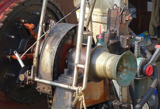 An old diesel powered winch to haul in the fishing net on a boat
