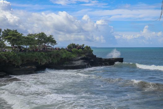Batu Bolong beach which has an tourism attraction spot, close to Tanah Lot temple on the top of the hill. Small bay and sandy beach adjacent to Pura Batu Bolong in Bali, Indonesia. Natural background.