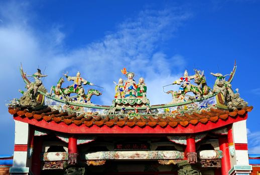 A Chinese temple with colorful decorations of mythological warriors