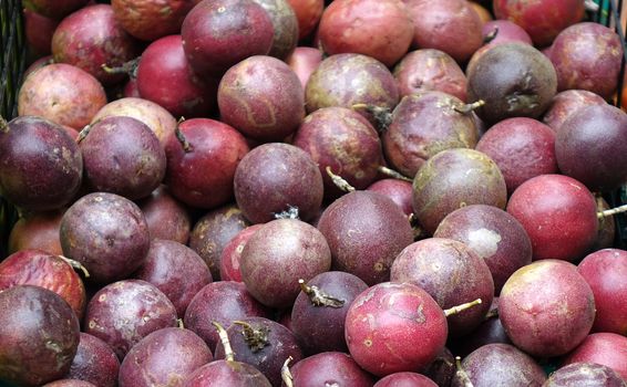 Purple passion fruits are sold at an outdoor market