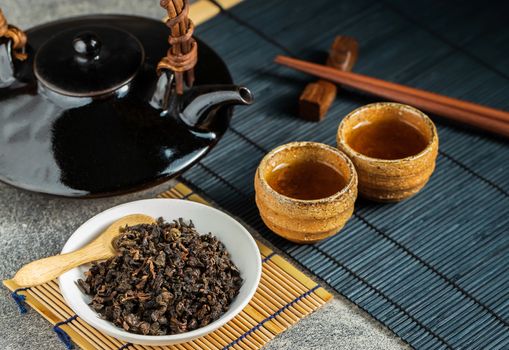 Hot tea in glass teapot and cup with steam