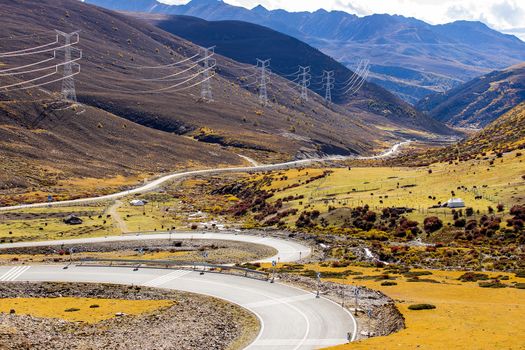Colorful landscape with beautiful mountain road with a perfect asphalt. High rocks, blue sky at sunrise in summer.