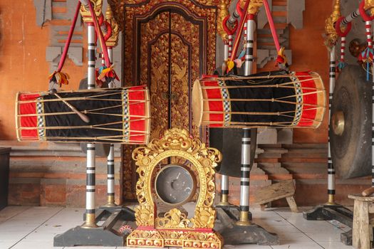 Musical instruments in a Hindu temple on Bali island, Indonesia. Drums and gongs suspended on load-bearing wooden ornate constructions. Musical instruments used in ceremonies.