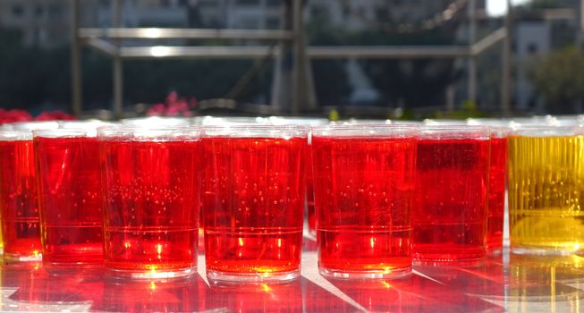 Glasses filled with sparkling red liquid in the morning sun
