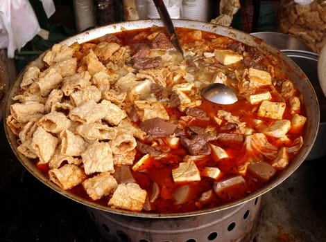 Outdoor vendor sells a spicy tofu stew with duck blood cakes
