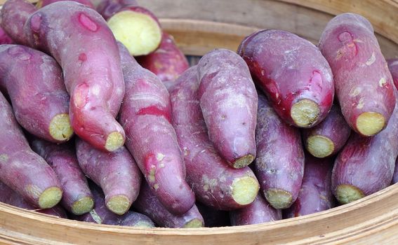 A street vendor sells steamed yams and sweet potatoes