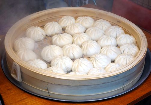 Chinese steamed buns stuffed with meat in a bamboo steamer