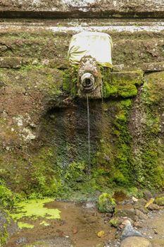 Gargoyles with holy water in the complex of royal tombs of the Udayan dynasty. Ancient royal tombs at Gunung Kawi Temple. Funeral complex centered around royal tombs carved into stone cliffs, Bali.