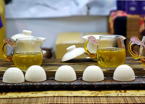 Elegant tea set with small porcelain bowls and glass teapots

